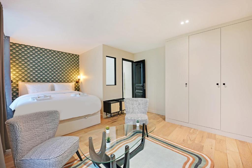 1 dormitorio con 1 cama, 2 sillas y mesa en Superb apartment 4 people center of Paris, en París