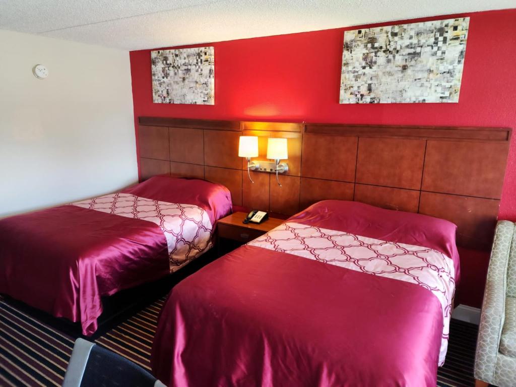 チェサピークにあるAmerican Inn Chesapeake - Portsmouthのベッド2台 ホテルルーム 赤い壁