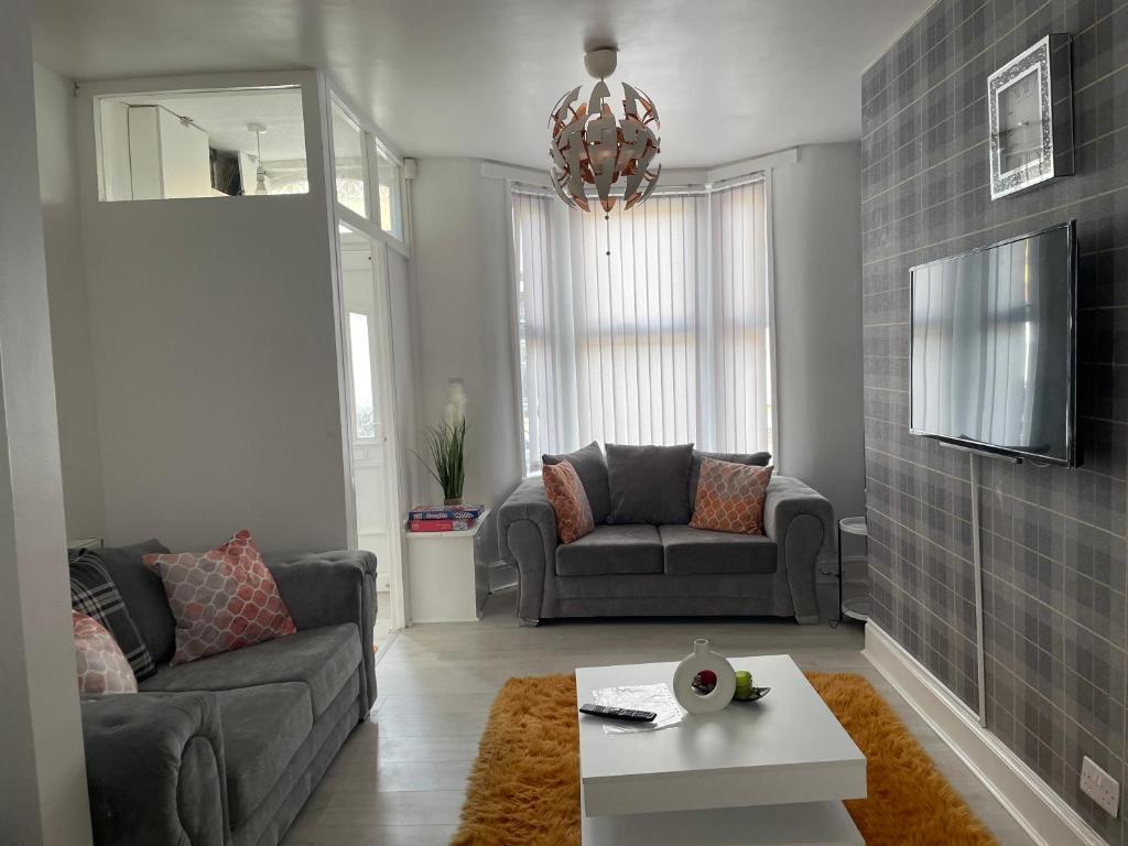 a living room with a couch and a table at Luxury Spacious 2 Bedroom Home. in Liverpool