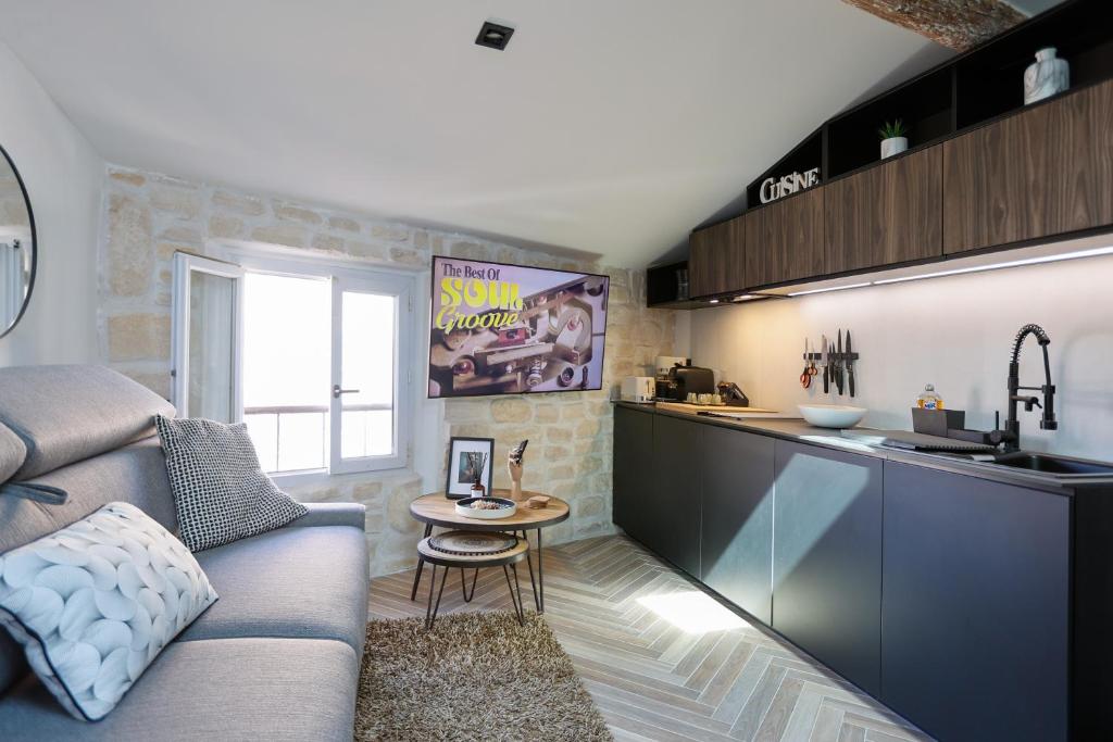 sala de estar con sofá y mesa en la cocina en Appartement sous les toits en Antibes