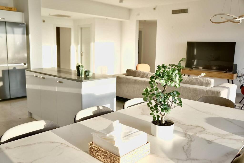 uma sala de estar com uma mesa com um vaso de plantas em Brand New Flat Seaview 4BDR 140m2 em Netanya