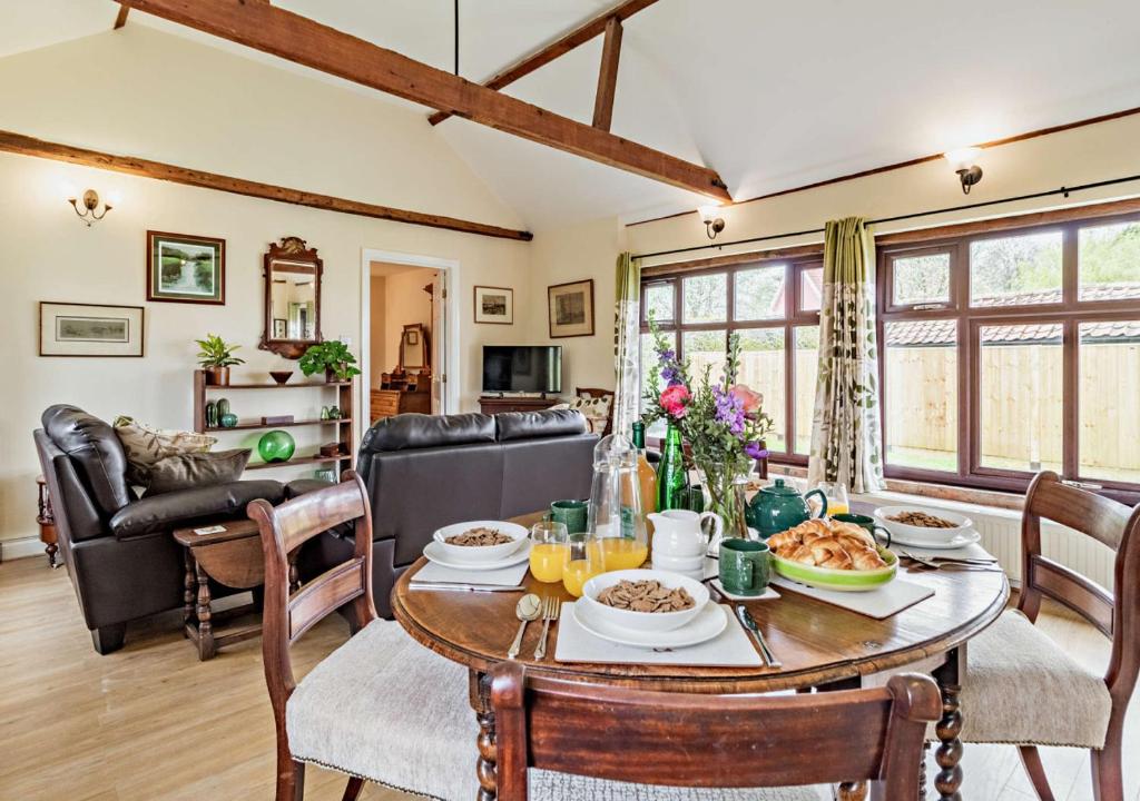 een woonkamer met een tafel met eten erop bij The White Horse Cottage in Saint James