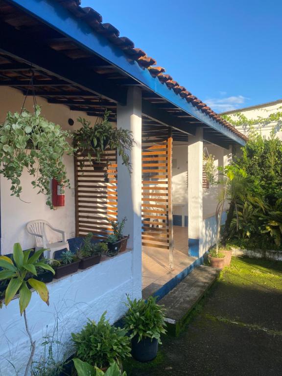 a house with a porch with plants on it at Pousada Via Maria in Cananéia