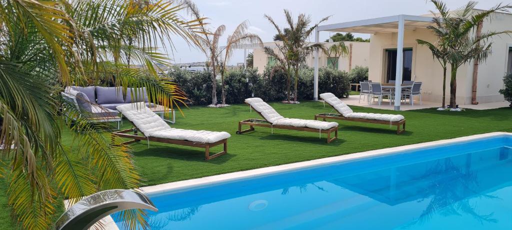 basen z leżakami i basen w obiekcie Villa Gisira - Luxury SPA w mieście Brucoli