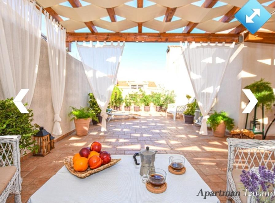 a table with a bowl of fruit on a patio at Apartmani Ina Pag in Pag