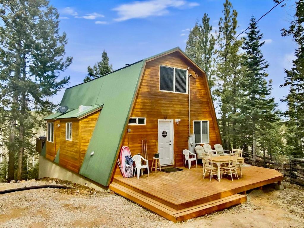 ein winziges Haus mit einer Terrasse und einem Tisch in der Unterkunft Woodchuck Cabin in Duck Creek Village