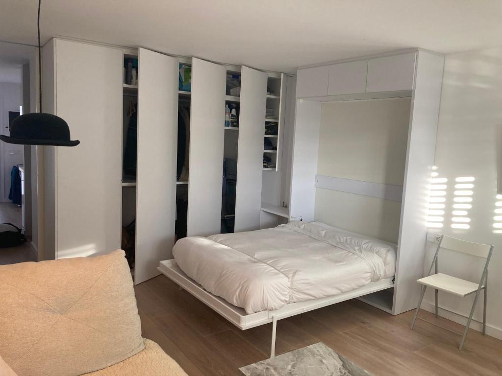 a bedroom with a bed with white walls at APARTAMENTO 10 MIN SITGES in Puigmoltó