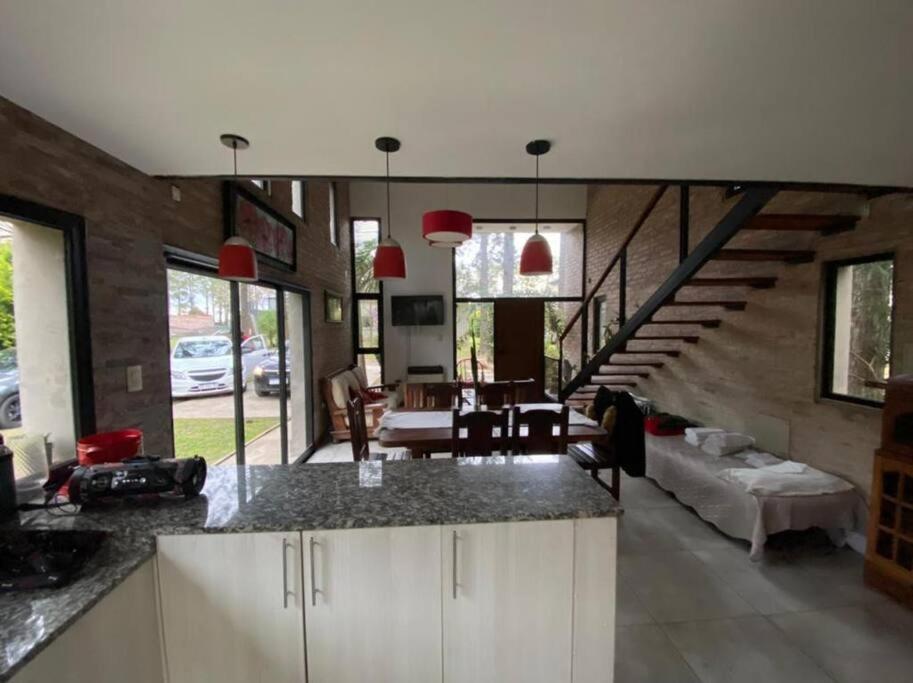 uma cozinha com uma sala de estar e uma escadaria em Casa en Country “El Pinar” em Santa Fé