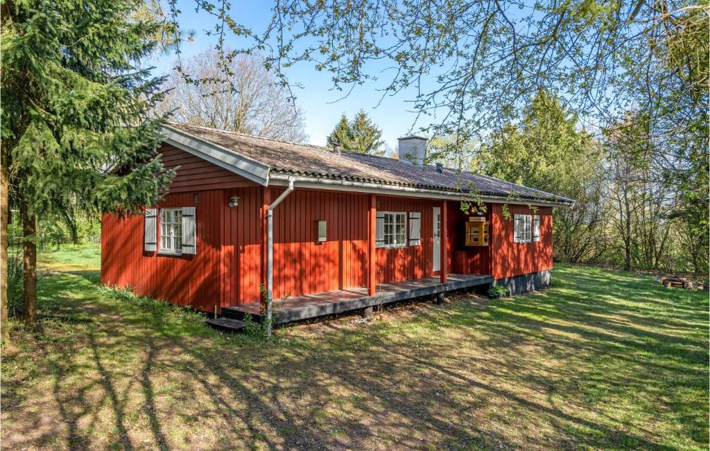 a red house in the middle of a yard at Beautiful Home In Munke Bjergby With Kitchen in Munke Bjergby