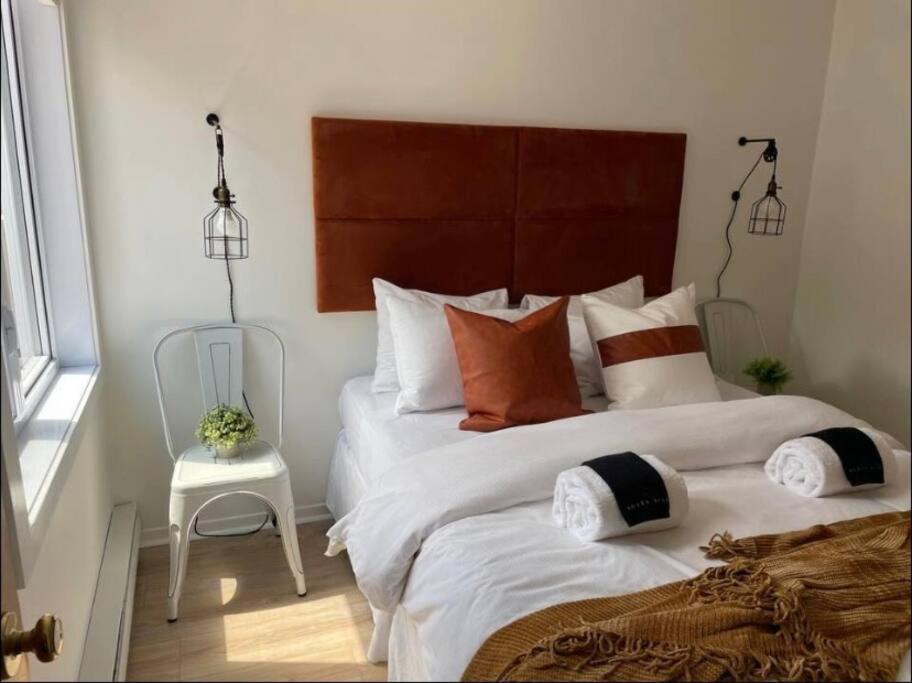 Un dormitorio con una cama grande con almohadas. en Tremblant Village Retreat!Steps to hill & trails, en Mont-Tremblant