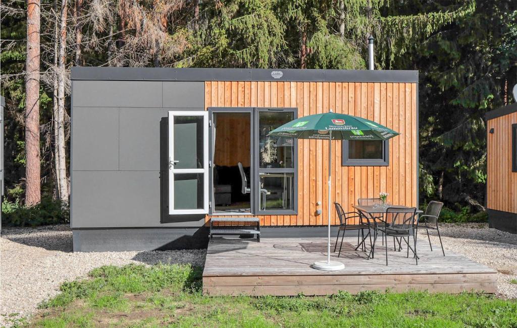 une petite maison avec une table et un parasol dans l'établissement Tiny Haus 85 Am Brombachsee, à Pleinfeld