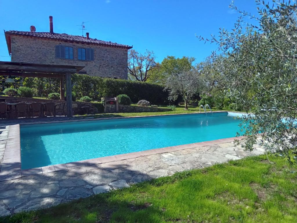 a swimming pool in the yard of a house at Podere Il Trebbio, porzione di villa in Gaiole in Chianti