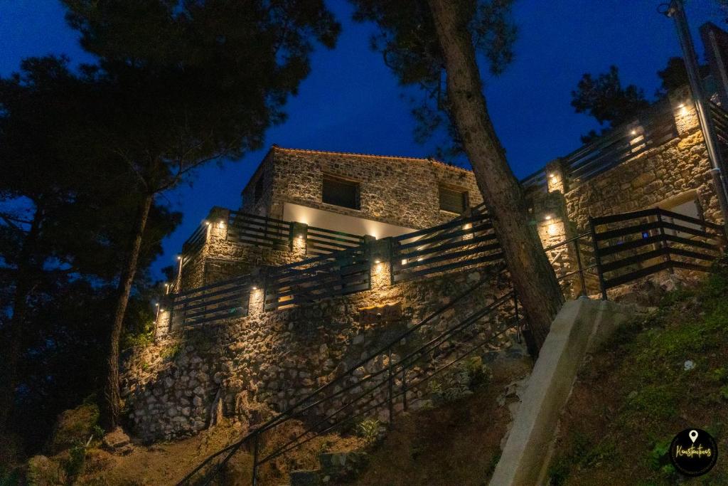 um velho edifício de pedra com luzes acesas à noite em Pinolia Rooms em Quios