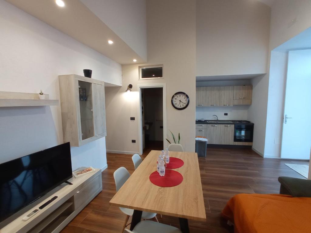 a living room with a table and a television at Suites Elifani in Trani