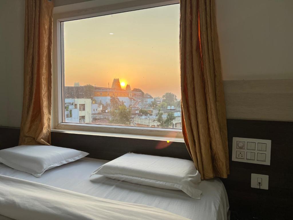 uma cama com uma janela com vista para a cidade em SRI BHAVYARESIDENCY em Bhadrachalam