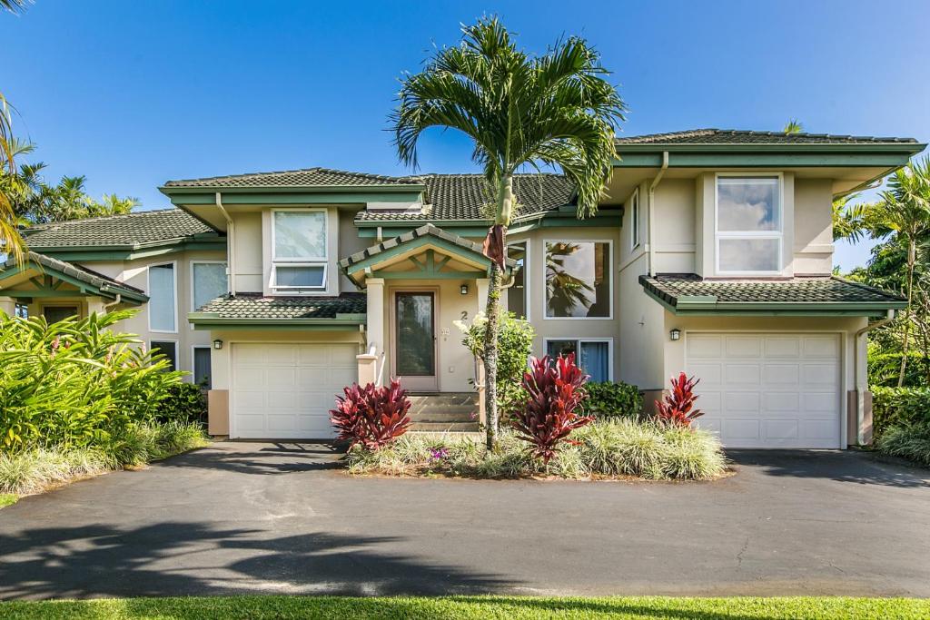 une maison avec un palmier en face dans l'établissement Kuu Lei Villa, à Princeville