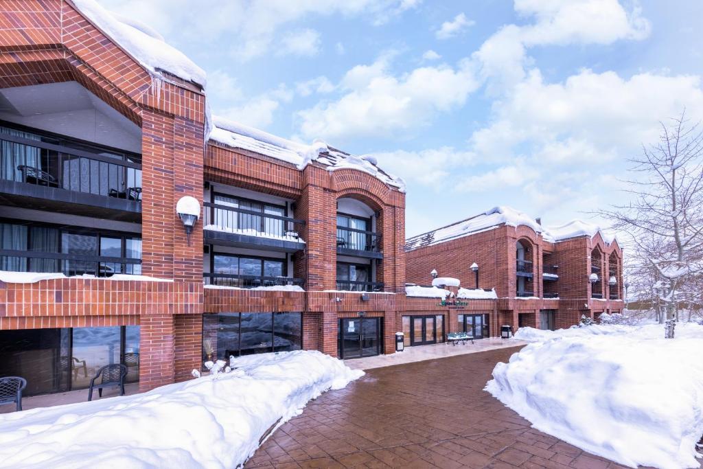 a brick building with snow in front of it at Raintree's Park Plaza Park City in Park City