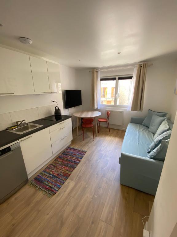 a kitchen and living room with a couch and a table at Le refuge du Touvet in Le Touvet