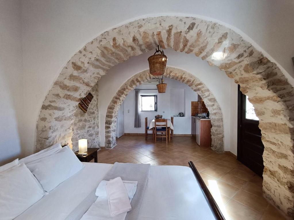 a room with an archway with a bed and a table at The Old barrel houses in Kythira
