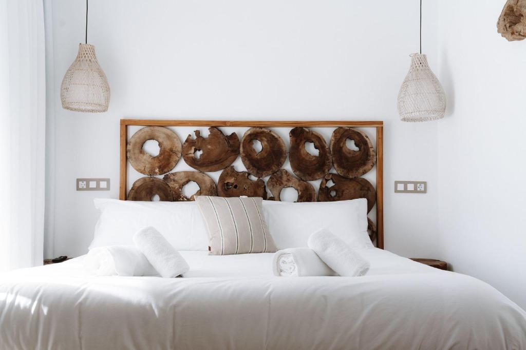 una camera con un letto bianco con due cuscini di Outsite Ibiza a Es Cana