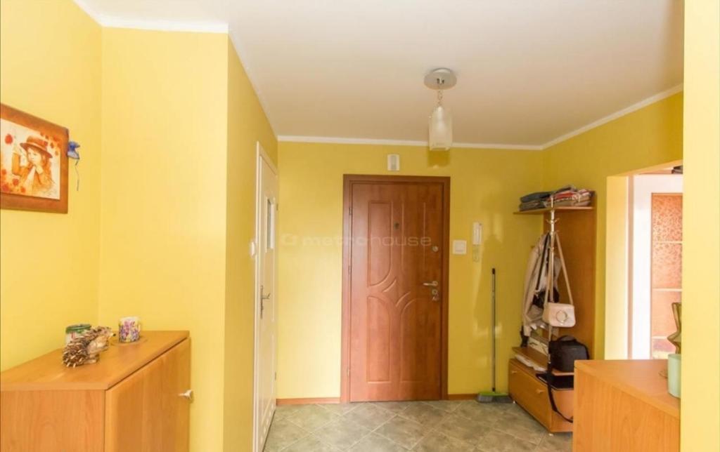 um quarto com paredes amarelas e uma porta de madeira em Słoneczny Apartament em Szczecinek