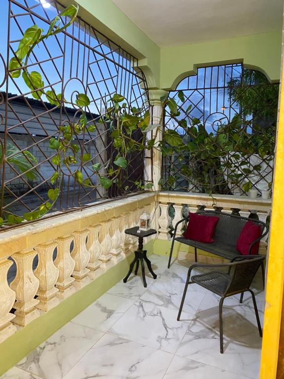 a balcony with a bench and a stained glass window at Merengue House in Boca Chica
