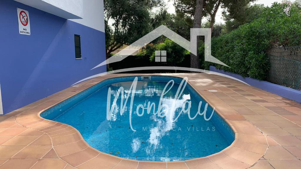 a swimming pool with a sign on the side of a house at SA TORRETA 4 in Cala Blanca