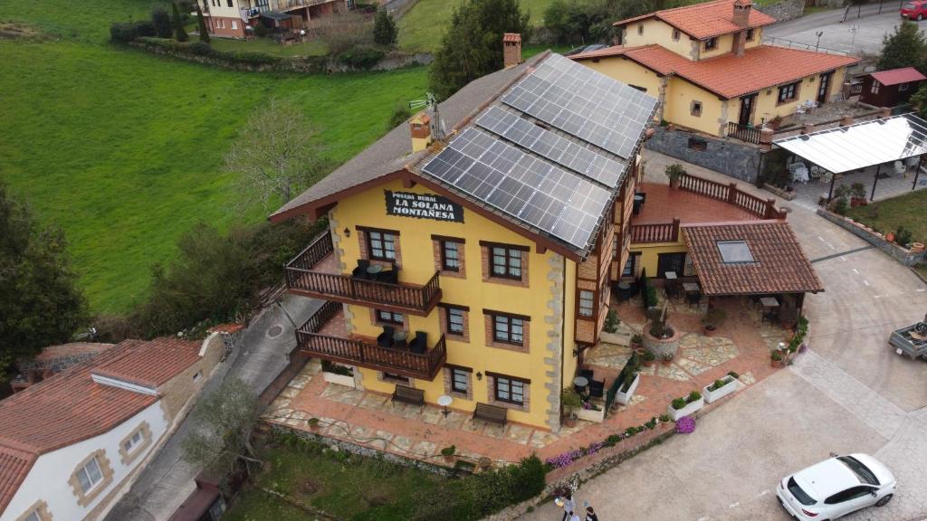 an overhead view of a large yellow house with a solar roof at La Solana Montañesa in Comillas