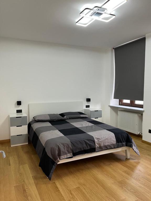 a bedroom with a bed and a flat screen tv at Appartamenti Dora Baltea in Ivrea