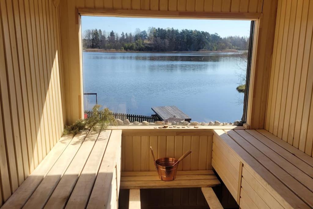 a window in a sauna with a view of a lake at Ezerdzirnas 