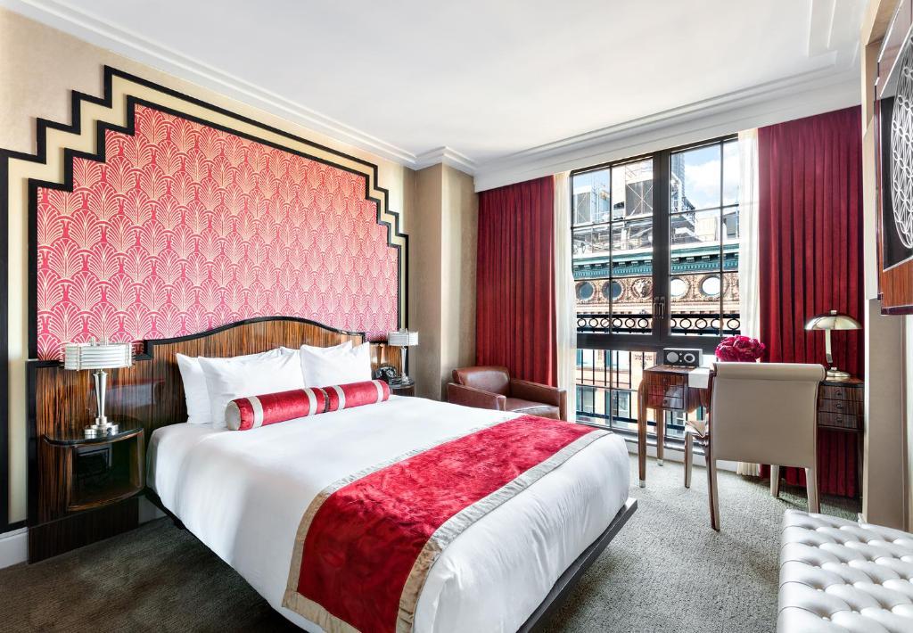 a bedroom with a large bed with a red headboard at Walker Hotel Greenwich Village in New York