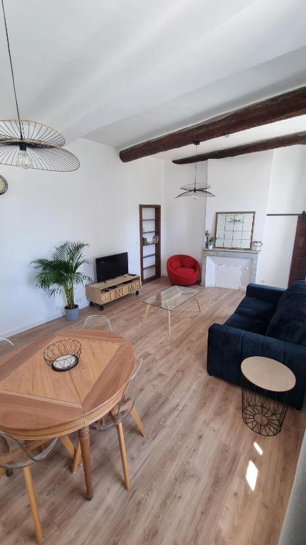 uma sala de estar com um sofá azul e uma mesa em En plein coeur de Pélissanne - 55 m2 rénovés - Avec Parking em Pélissanne