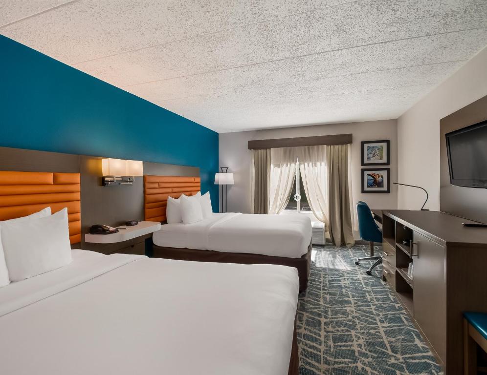 a hotel room with two beds and a flat screen tv at Comfort Inn Falls Church - Tysons Corner in Falls Church