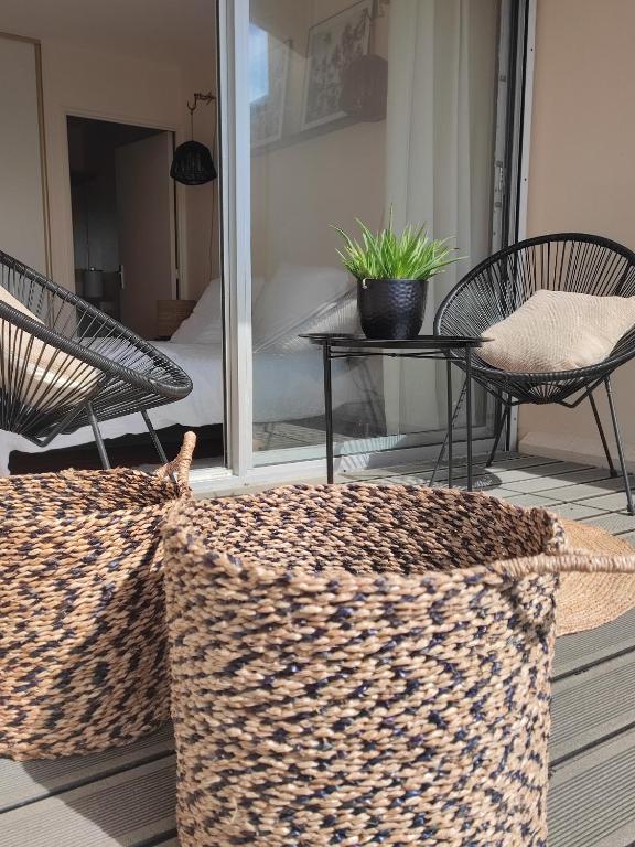 un patio avec deux chaises, une table et une couverture dans l'établissement Le 3 appartement vue mer avec jardin 100m de la plage et de la thalasso, à Concarneau