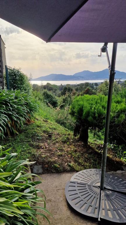 un parasol posé sur une terrasse avec vue dans l'établissement Villa Terra Bella, à Grosseto-Prugna