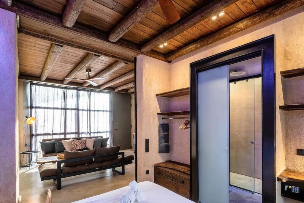 Zimmer mit einem Bett und einem Wohnzimmer mit einem Sofa in der Unterkunft Sea View Garden Suites in Piräus