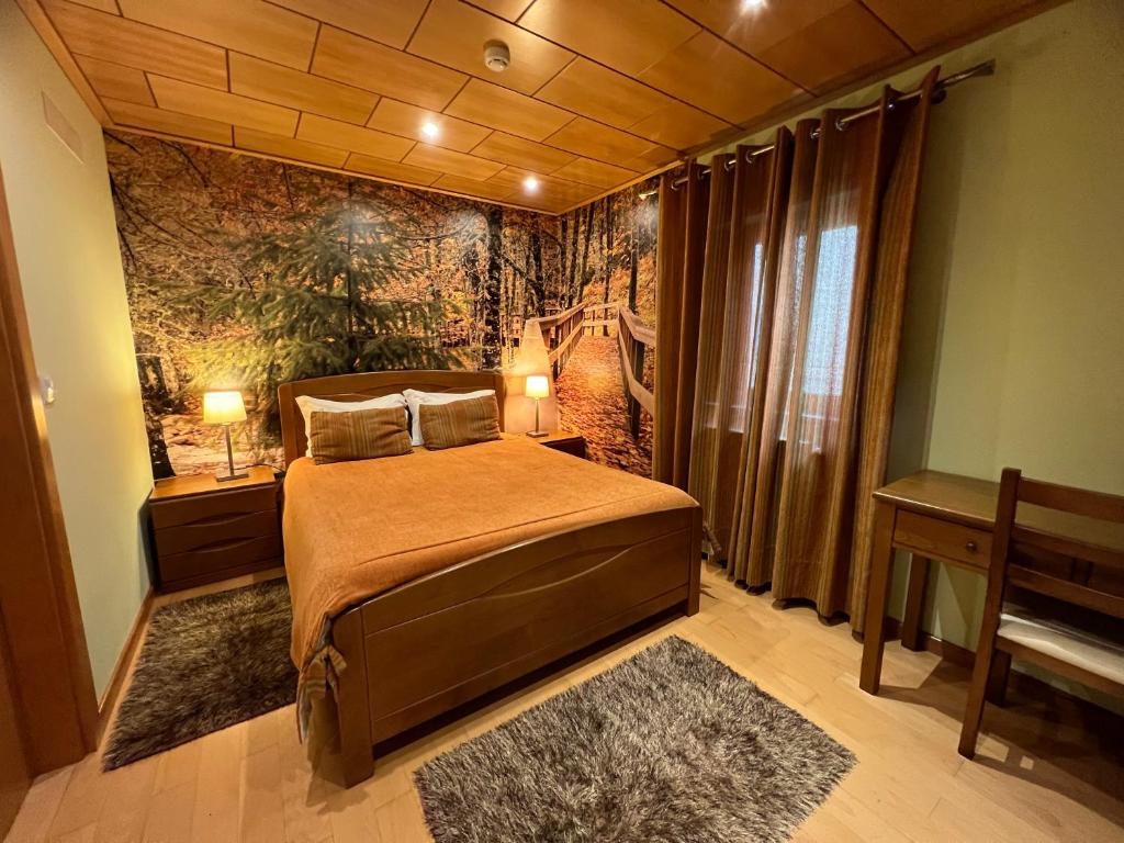 um quarto com uma cama e um mural de parede em Casa do Telheiro em Sabugueiro