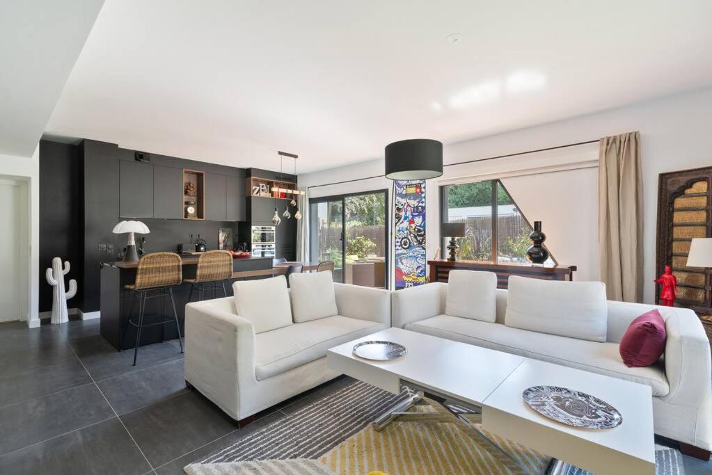 un salon avec un canapé blanc et une cuisine dans l'établissement Appart standing Btz Anglet plage, à Anglet