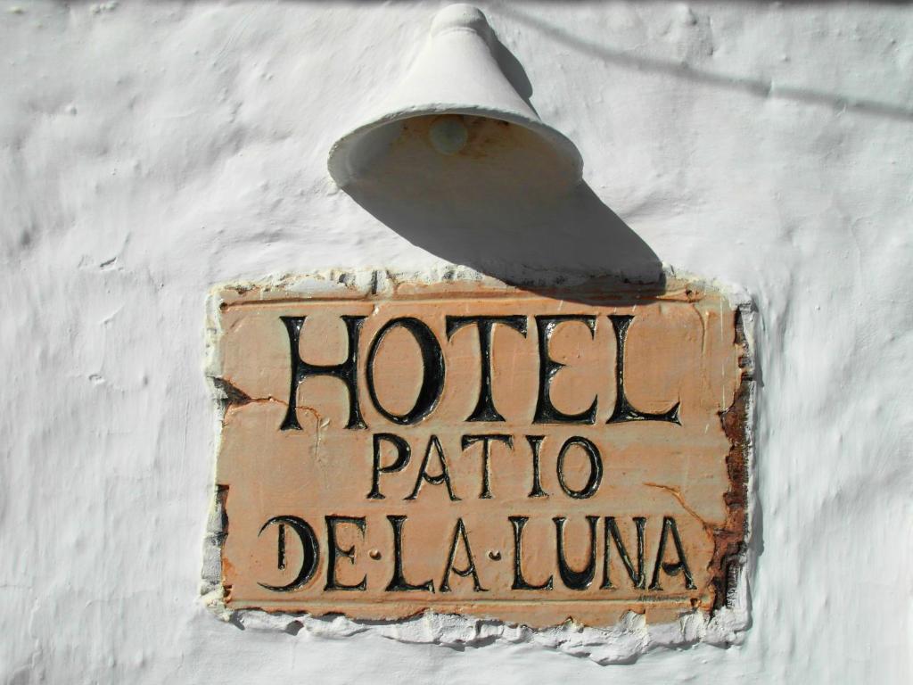Patio De La Luna في أصيلة: علامة مرفقة بمبنى به ضوء الشارع