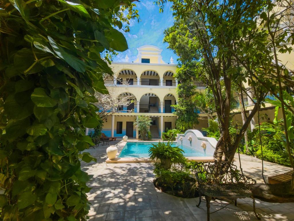 an exterior view of a building with a swimming pool at Hotel Fundadores in Valladolid