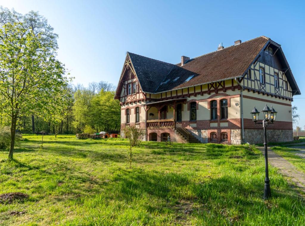 an old house with a green field in front of it at Forsthaus Nauen in Nauen