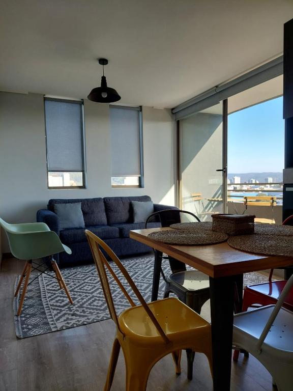 a living room with a couch and a table and chairs at Departamento Ejecutivo Concepción in Concepción