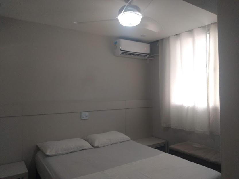 een slaapkamer met een wit bed en een raam bij Apto Lindo Agua in Campos dos Goytacazes