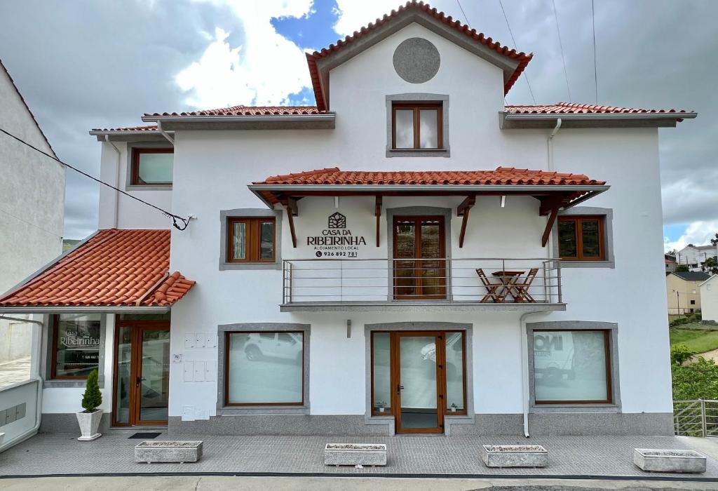 a white building with a sign on it at Casa da Ribeirinha in Sabugueiro