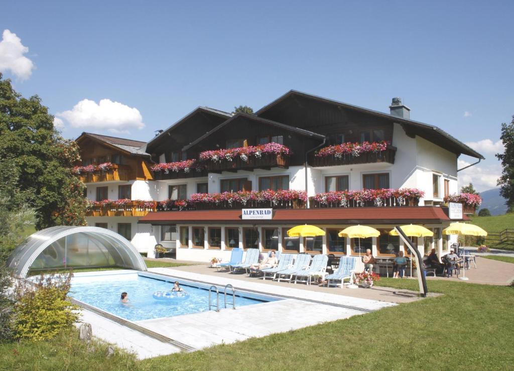 a hotel with a swimming pool in front of a building at Alpenbad in Ramsau am Dachstein