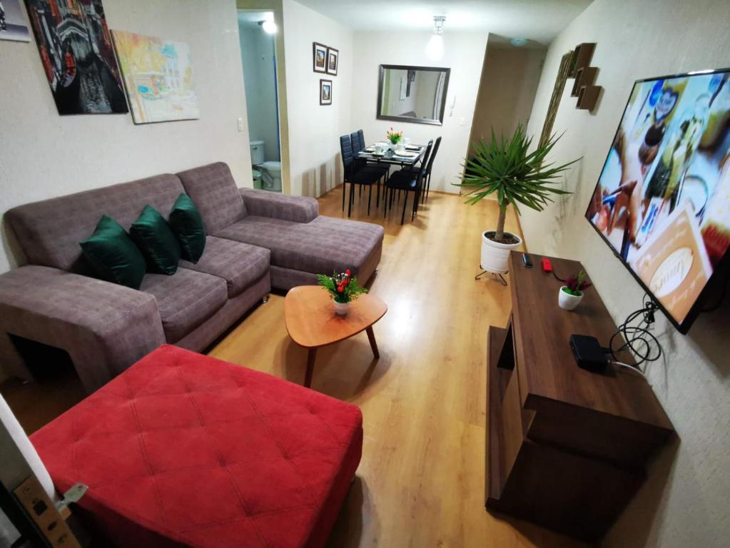 un soggiorno con divano e tavolo di Hermoso departamento en condominio a Tacna