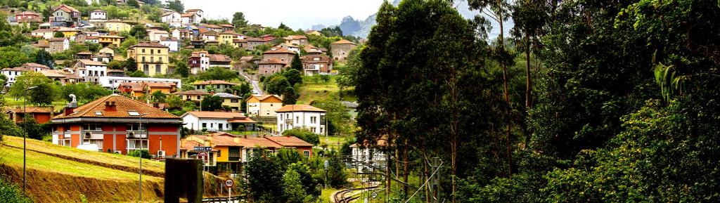 una ciudad en una colina con casas en una montaña en Hotel El Mirador del Nalon, en San Román