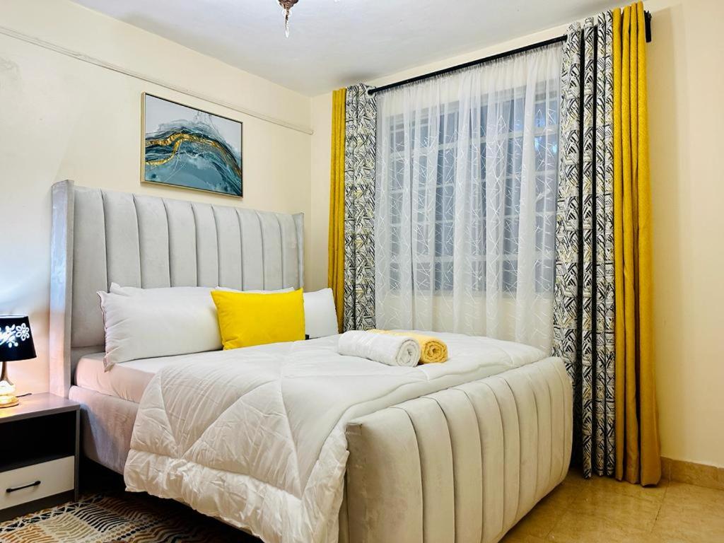 1 dormitorio con 1 cama grande y ventana en Vob cosy home, en Eldoret