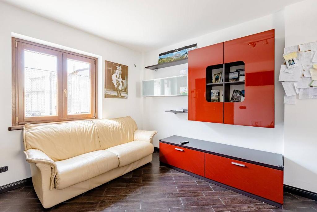 Oleandro Room في سان سيفيرينو لوكانو: غرفة معيشة مع أريكة وخزانة حمراء