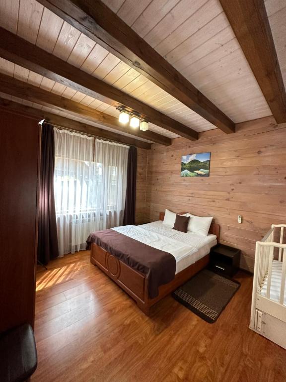 um quarto com uma cama num quarto de madeira em Dacha 6 em Voropayev